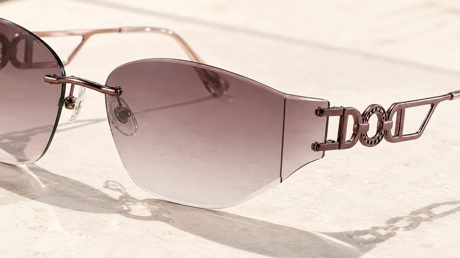 Close-up detail of rimless sunglasses showing bridge, lens edge, and mounting construction