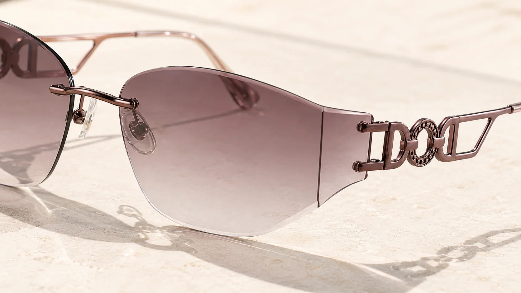 Close-up detail of rimless sunglasses showing bridge, lens edge, and mounting construction