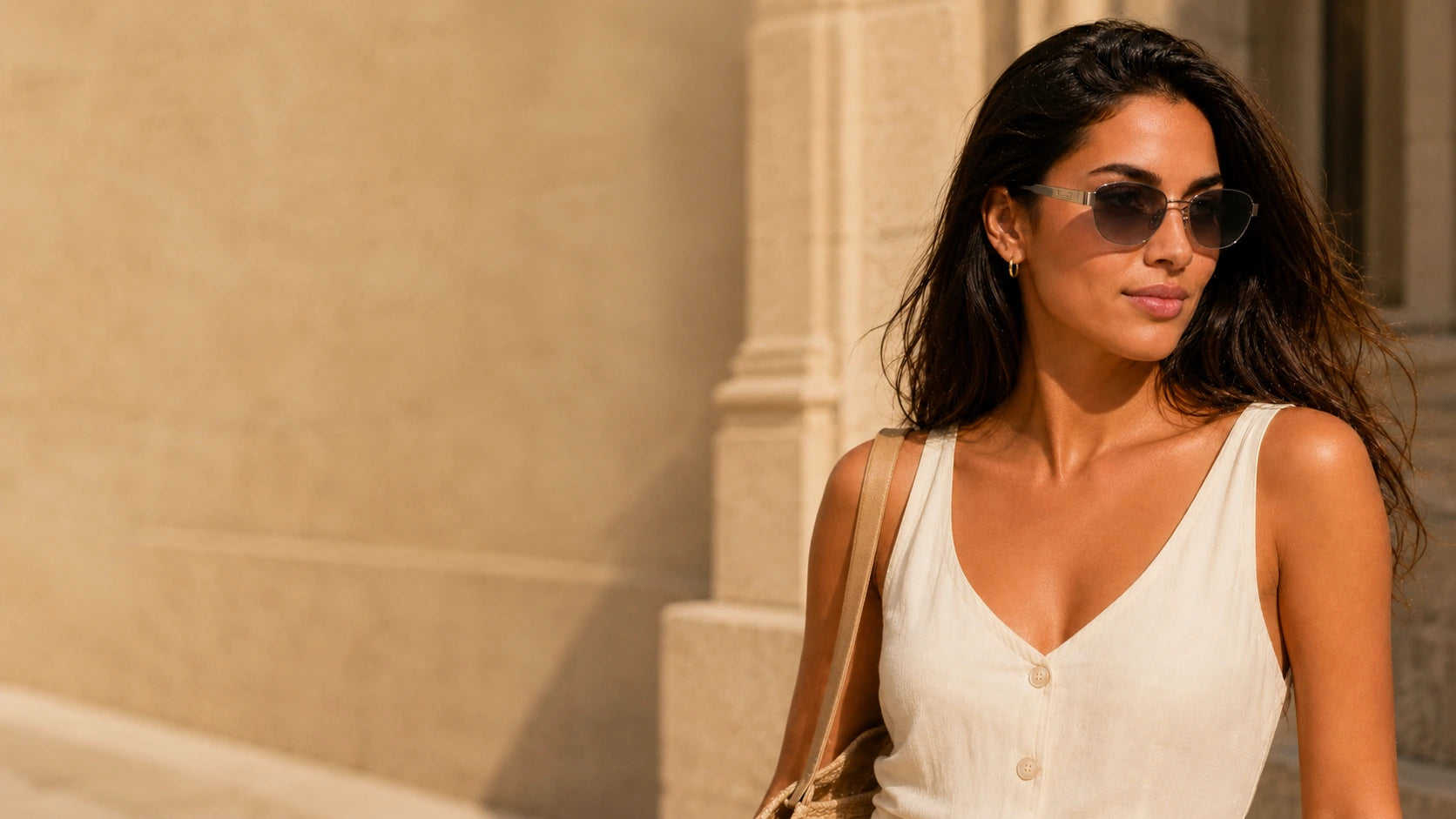 BAPORSSA Aurelia gunmetal sunglasses with smoke gradient lenses worn by a woman in an elegant sunlit city setting