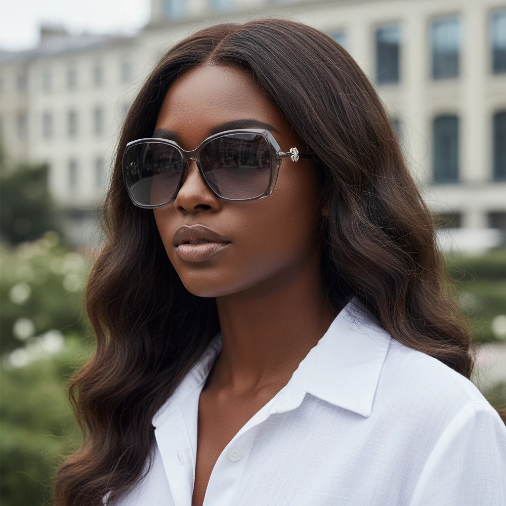 Woman wearing sunglasses and a white shirt with a blurred building background