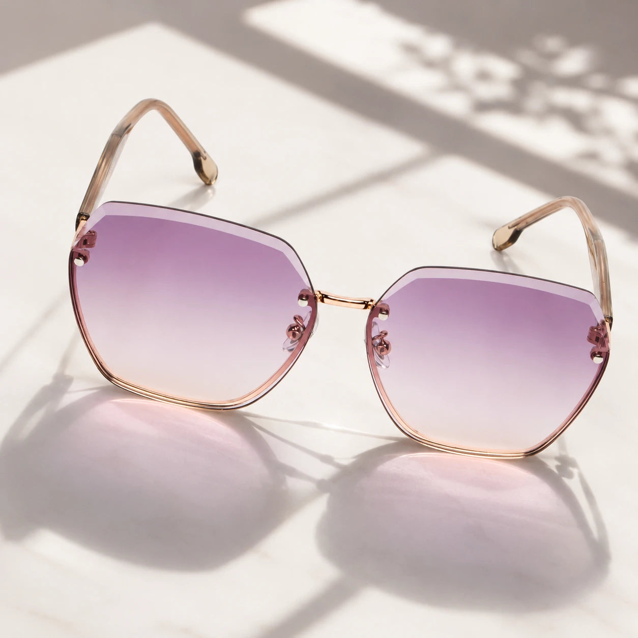 BAPORSSA Contour rimless sunglasses with oversized geometric purple pink gradient lenses placed in soft sunlight