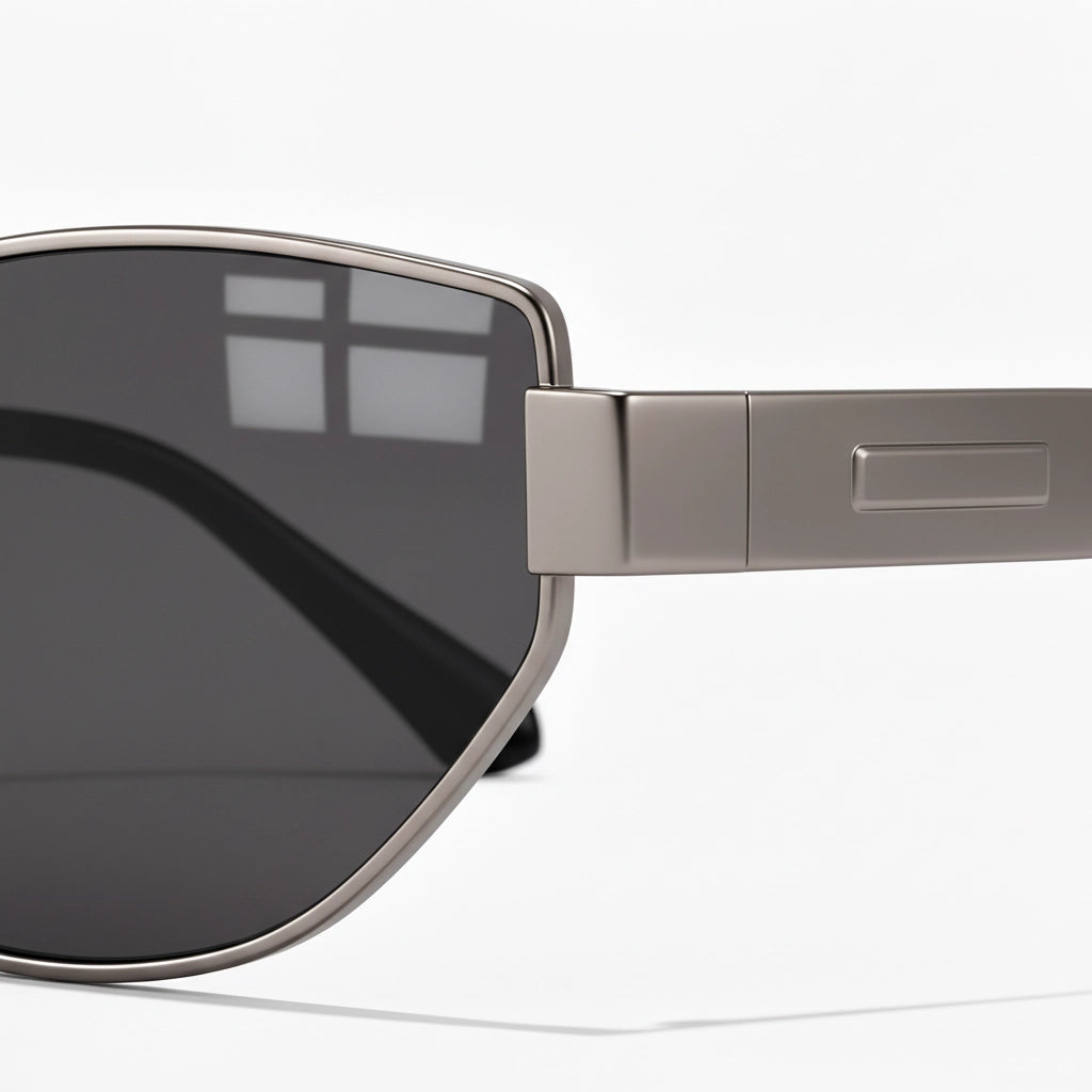 Close-up of titanium alloy sunglasses, showing details of the metallic gray frame and the reflection from the dark gray lenses.