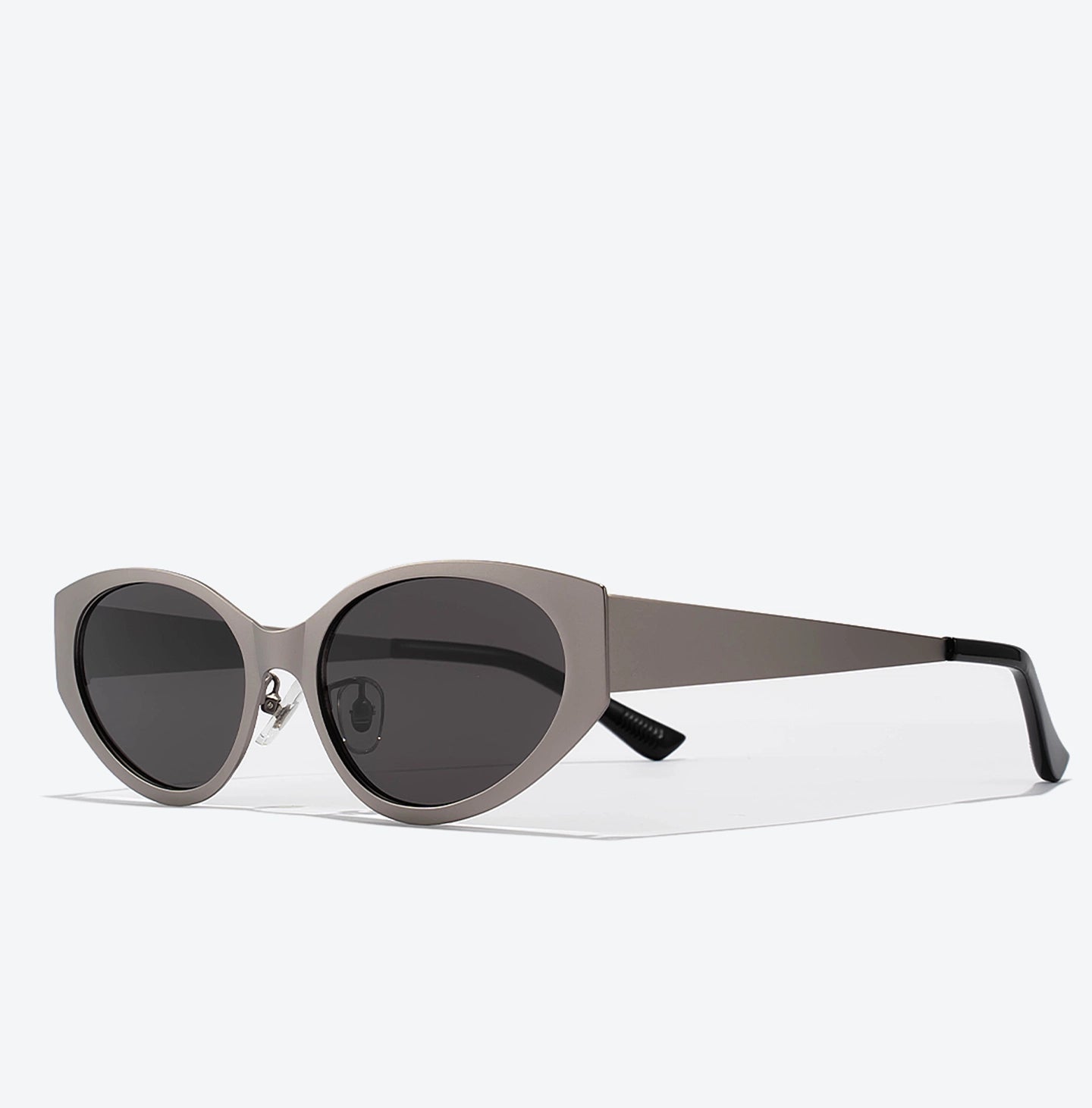 Sunglasses with a white frame and dark lenses on a light gray background