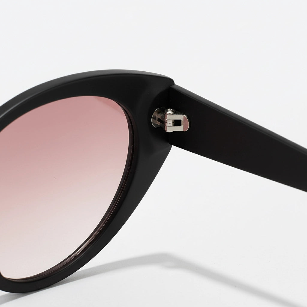Black sunglasses with pink gradient lenses on a light gray background