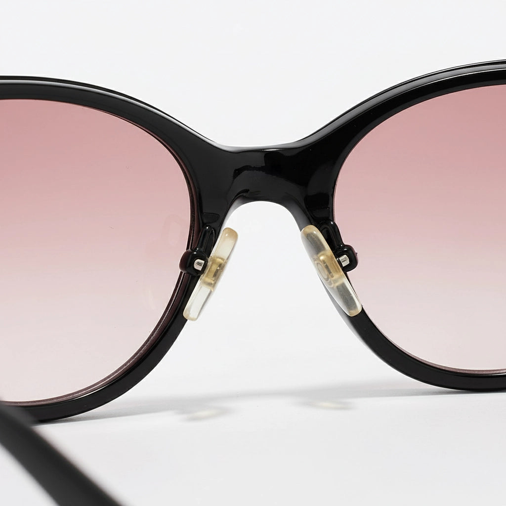Black sunglasses with pink lenses on a white background