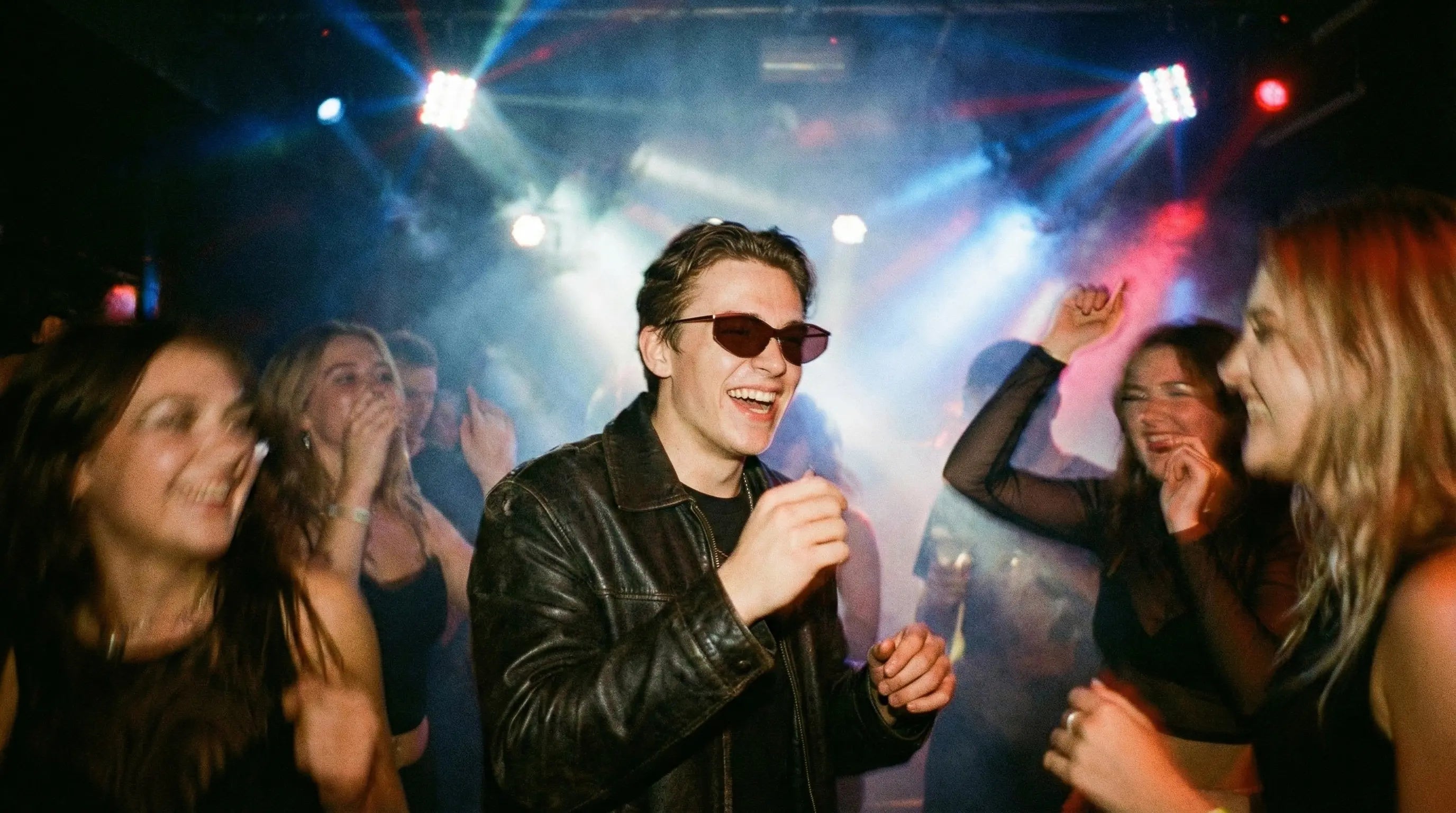 Red-tinted polarized sunglasses cutting club stage light glare, stylish for nightlife.