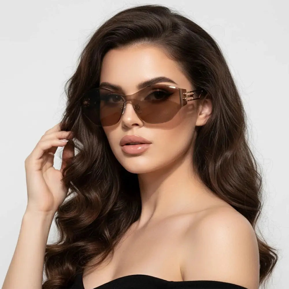 A woman wears oversized translucent brown cat-eye sunglasses with a black off-shoulder top, highlighting the style’s sleek, glamorous design that elevates formal and casual outfits.