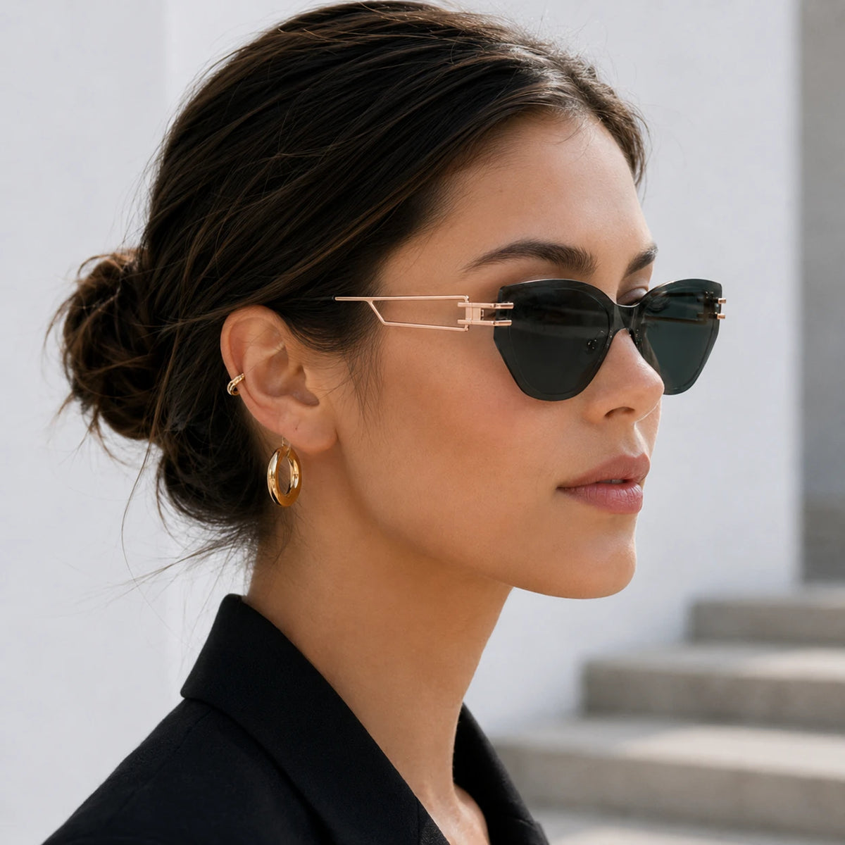 Side profile of a woman with her hair in a bun, showcasing the elegant gold geometric temple design of Baporssa Edge dark green sunglasses.