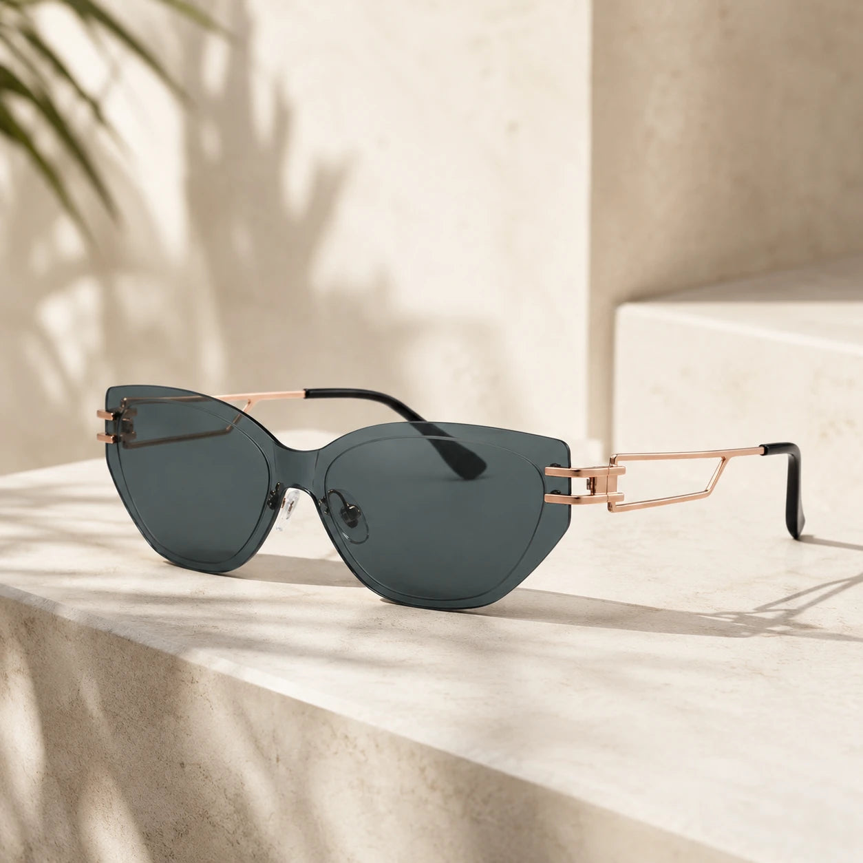 A high-end still life shot of Baporssa Edge rimless cat-eye sunglasses with dark green lenses and rose gold metal temples, resting on a beige stone staircase.