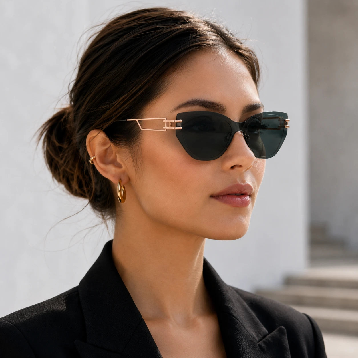 A close-up side profile portrait of a woman wearing Baporssa Edge rimless cat-eye sunglasses with translucent dark green lenses and rose gold metal temples.