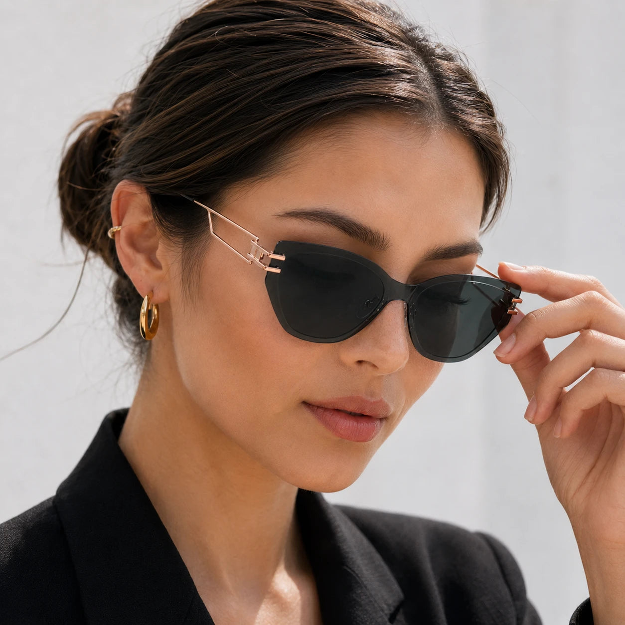 A close-up portrait of a woman gently touching the rose gold temple arm of her Baporssa Edge rimless dark green fashion sunglasses.