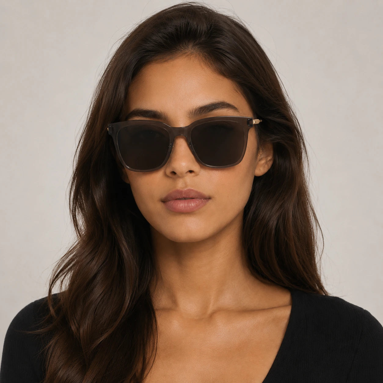 Front portrait of a woman wearing Baporssa Halo oversized square sunglasses with translucent jelly grey frames and dark lenses.