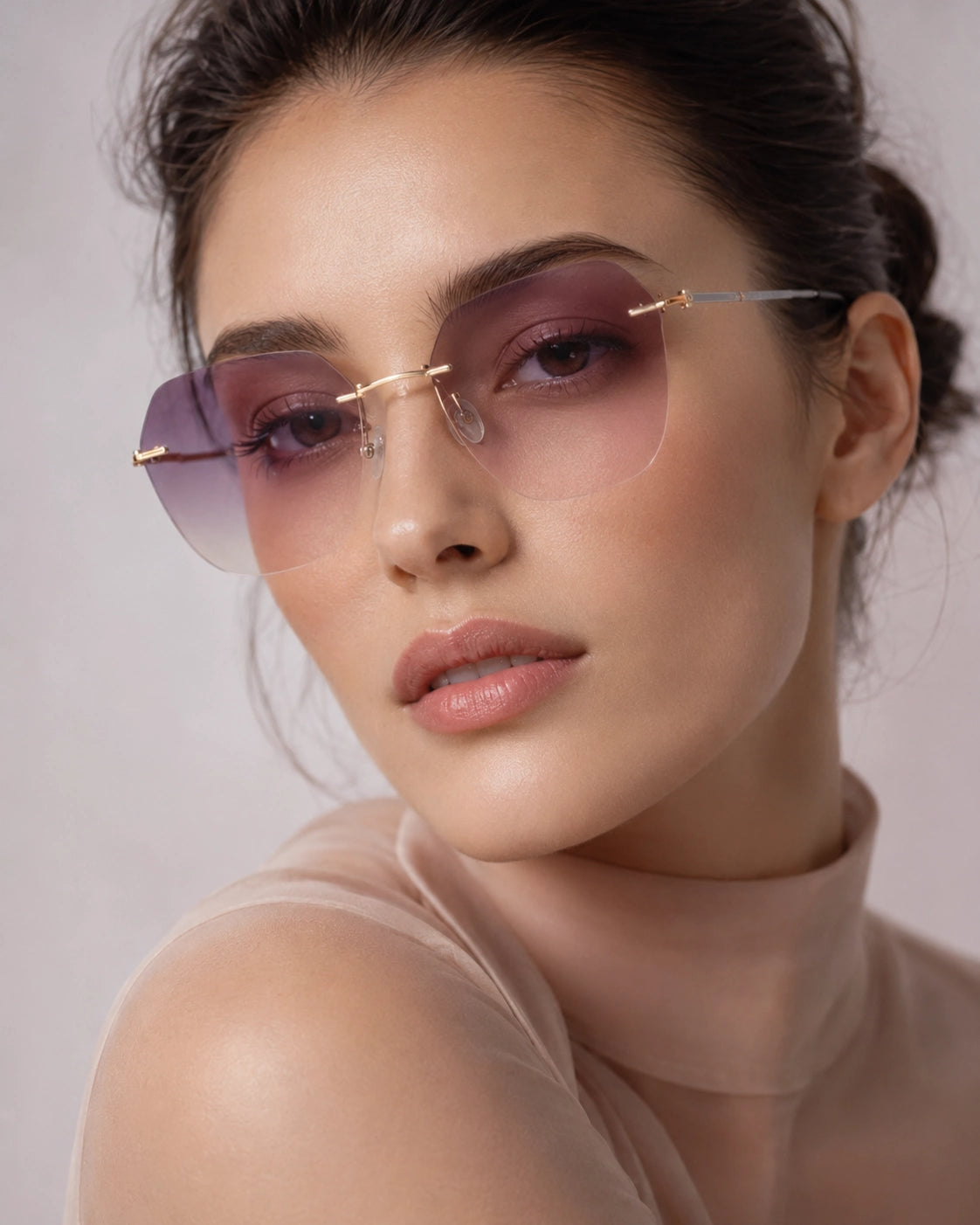 Close-up of rimless hexagonal purple gradient sunglasses with gold bridge detail