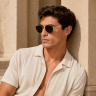 Male model wearing BAPORSSA Aurelia vintage cat-eye sunglasses with gold metal frame and dark smoke lenses in warm sunlight