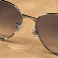 Close-up of BAPORSSA Aurelia sunglasses showing adjustable nose pads, smoke gradient nylon lenses, and slim metal bridge
