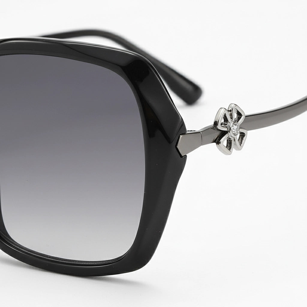 Black sunglasses with a decorative bow on a white background