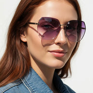 Woman wearing purple sunglasses with a white background
