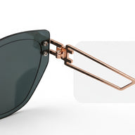 Sunglasses with a rose gold frame and dark lenses on a light gray background
