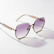 Sunglasses with purple gradient lenses and gold frame on a light gray background
