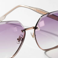 Sunglasses with purple lenses and gold frame on a white background