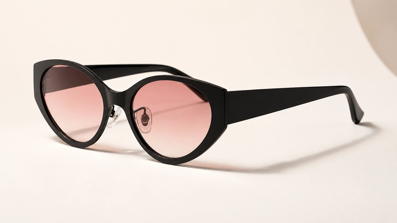 Side-angle professional product shot of BAPORSSA Lyra cat-eye
     sunglasses with a premium black frame and vibrant pink-to-clear gradient
     lenses