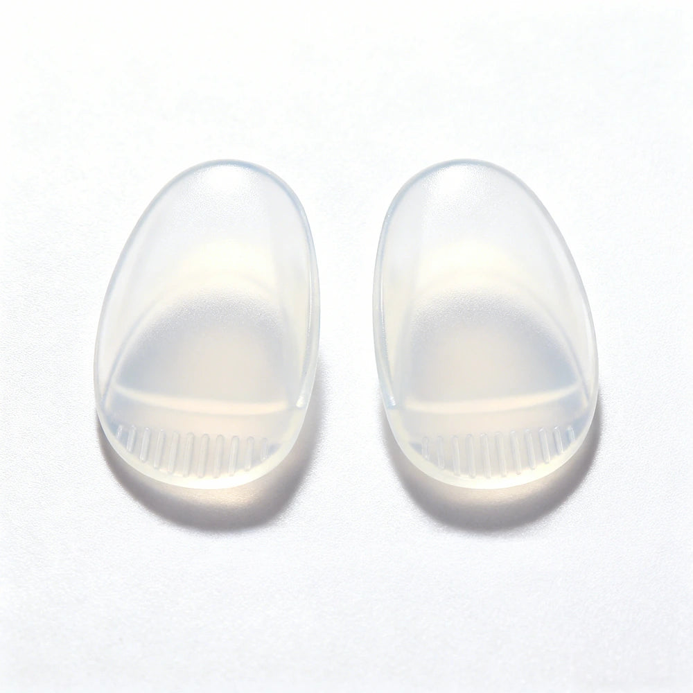 A pair of transparent silicone nose pads, emphasizing their soft texture and ergonomic shape, designed to enhance comfort and fit in glasses or sunglasses.