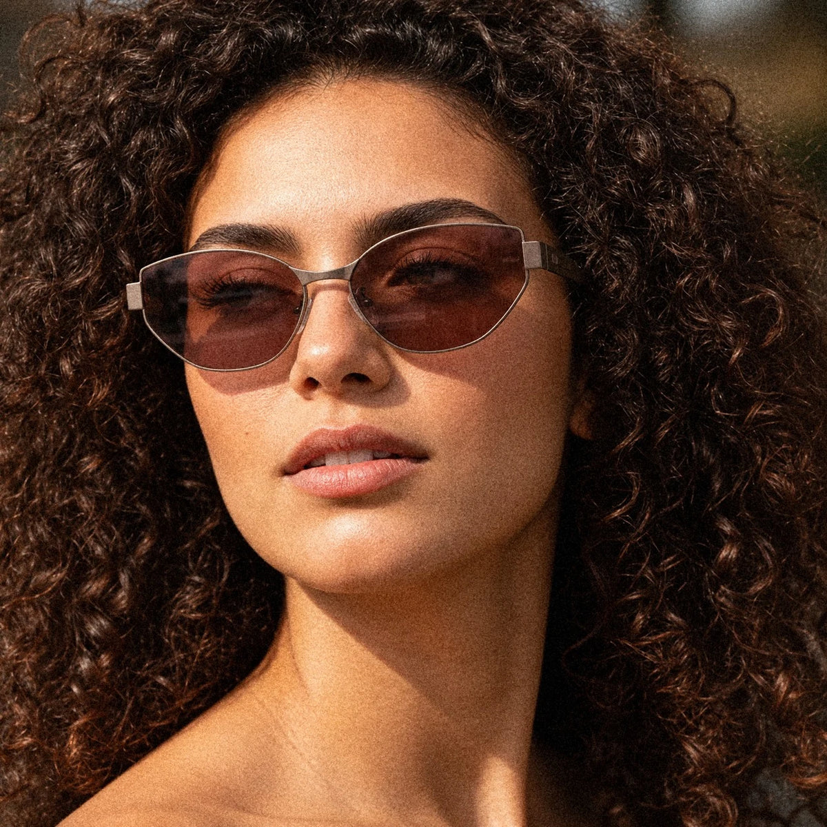 BAPORSSA Onyx titanium cat-eye sunglasses in Claret, worn by a model, close up