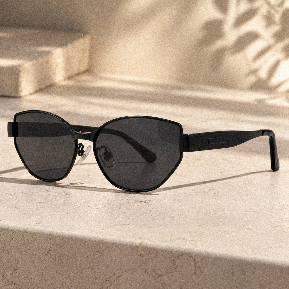 BAPORSSA Onyx sunglasses in Black on a stone ledge