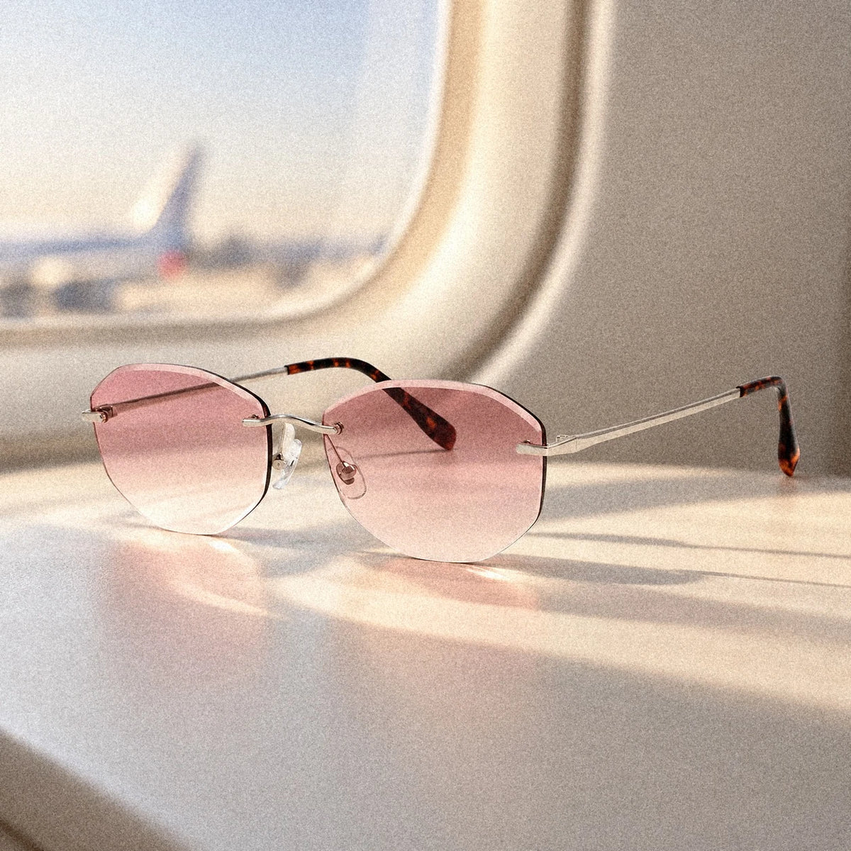 Backbone Luminous Rose rimless sunglasses in soft window light