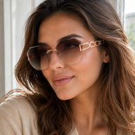 Side profile portrait of a woman looking away, wearing Baporssa oversized rimless sunglasses with brown gradient lenses and a decorative rose gold geometric hollow temple.
