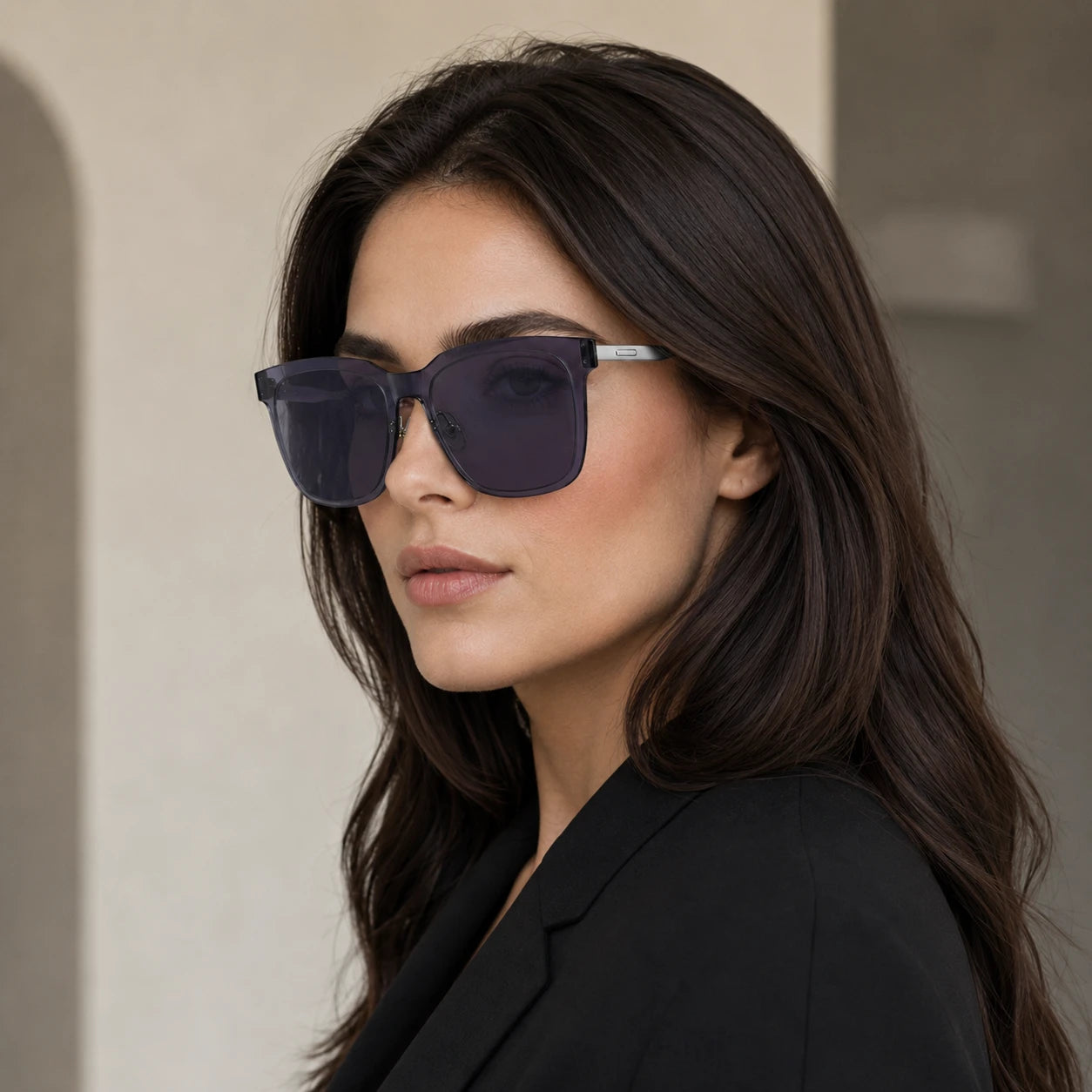 Side profile of a woman wearing Baporssa Halo square sunglasses, highlighting the seamless design of the translucent dark grey frame and slim silver temple arm.