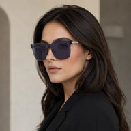 Side profile of a woman wearing Baporssa Halo square sunglasses, highlighting the seamless design of the translucent dark grey frame and slim silver temple arm.