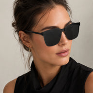 Three-quarter view portrait of a woman wearing Baporssa Halo square sunglasses, showing the seamless connection of the black frame and slim temple.