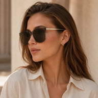 Side profile portrait of a woman wearing Baporssa Halo oversized grey acetate sunglasses, showcasing the elegant gold temple arms.