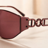 Macro detail shot of Baporssa Muse sunglasses temple arm, emphasizing the dark metallic interlocking geometric design and studded circular loop detail.
