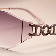 A macro detailed shot of Baporssa Muse sunglasses, focusing on the sophisticated interlocking letter design and rhinestone circular embellishments on the metal temple arm.