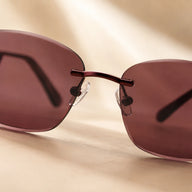 Close-up shot focusing on the polished metallic nose bridge and adjustable clear nose pads of Baporssa Muse rimless dark tinted sunglasses.