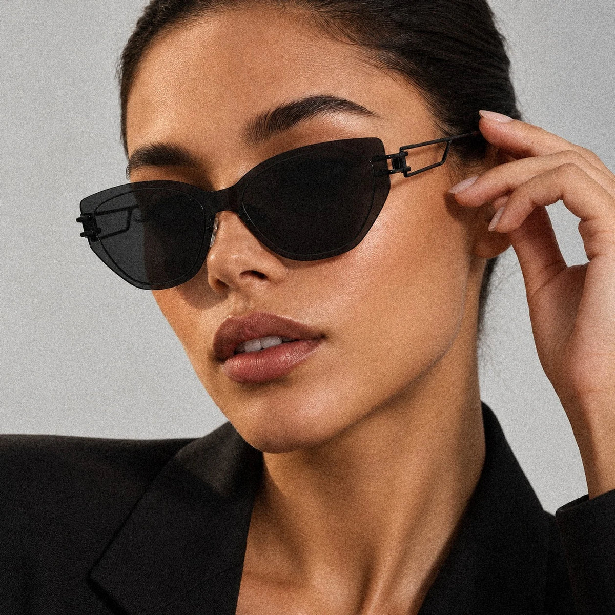 BAPORSSA Edge sharp cat-eye sunglasses in Black, worn by a model, close up