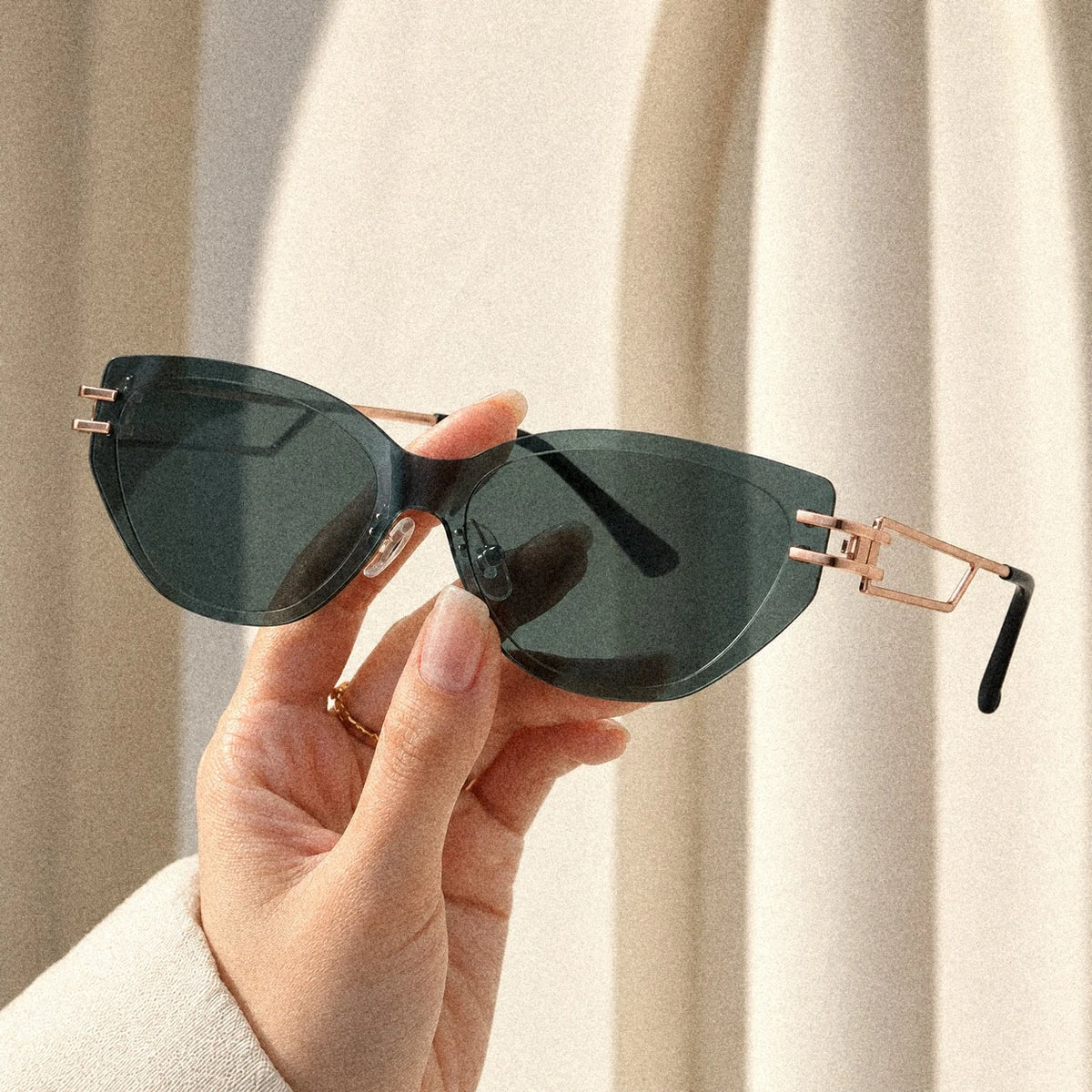 Hand holding BAPORSSA Edge sunglasses in Grey-Green