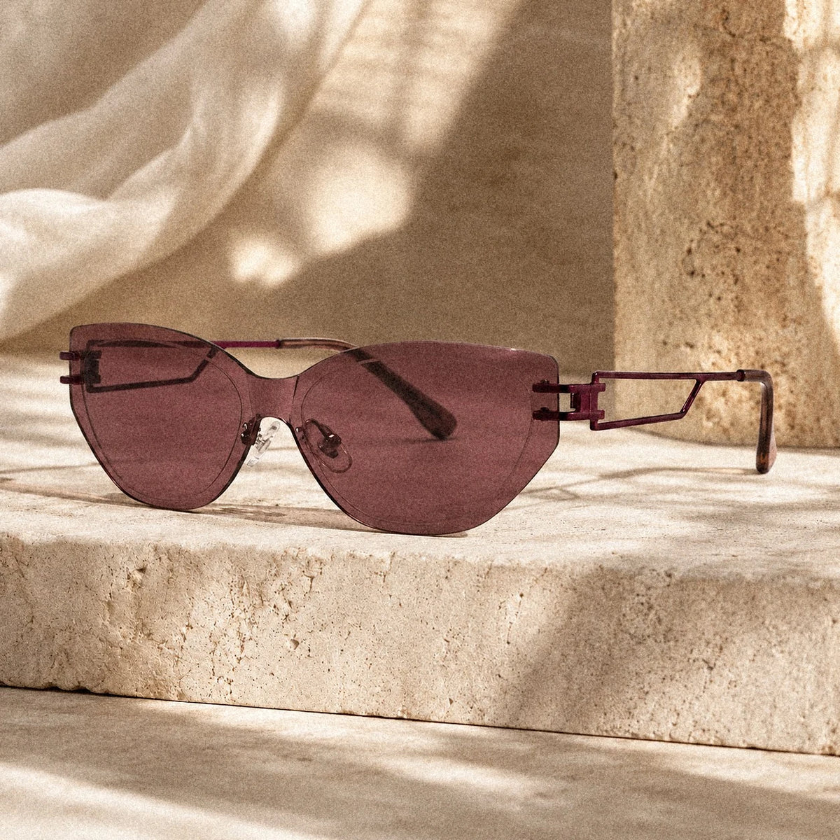 BAPORSSA Edge sunglasses in Claret on a stone ledge