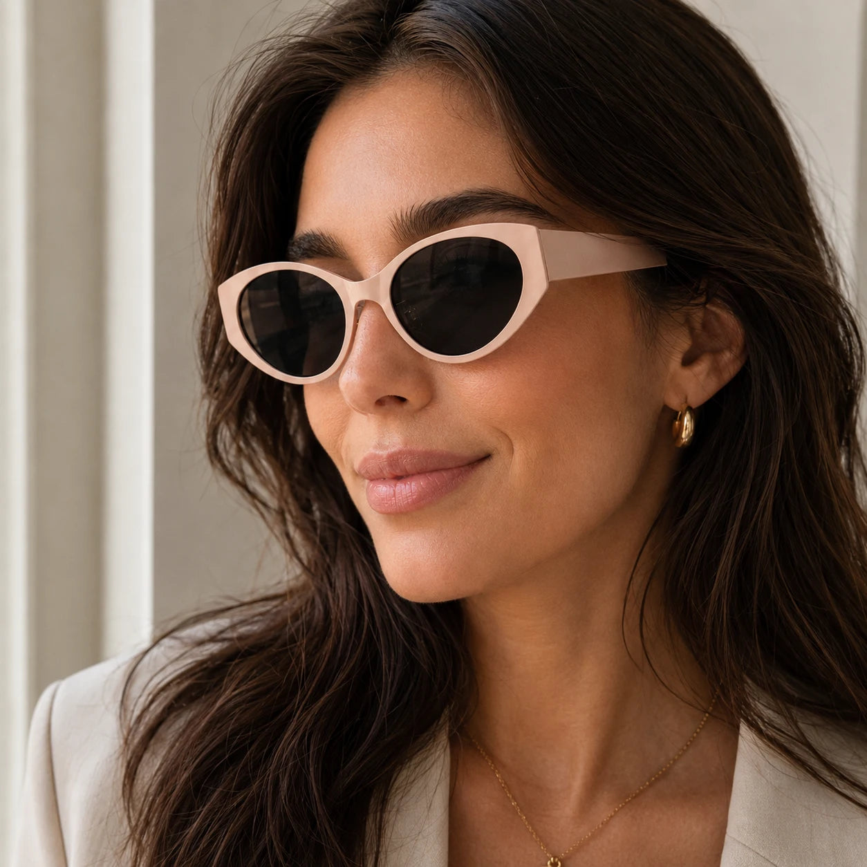 Side profile of a woman wearing Lyra chunky nude beige sunglasses with dark lenses looking sideways.