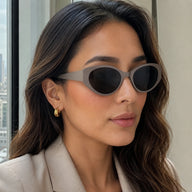 Side profile of a woman wearing chunky Lyra gray acetate sunglasses with dark lenses.