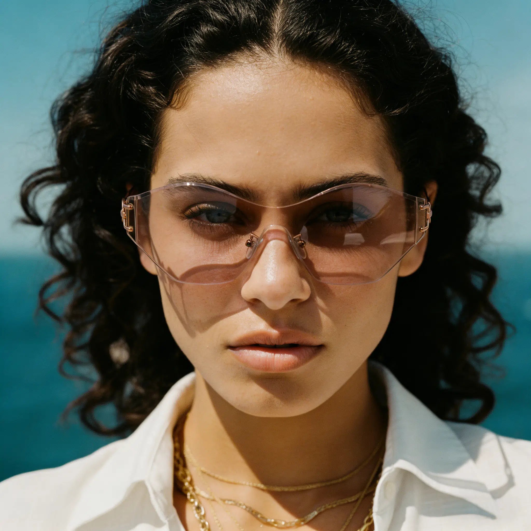 Woman wearing sunglasses with a blurred ocean background