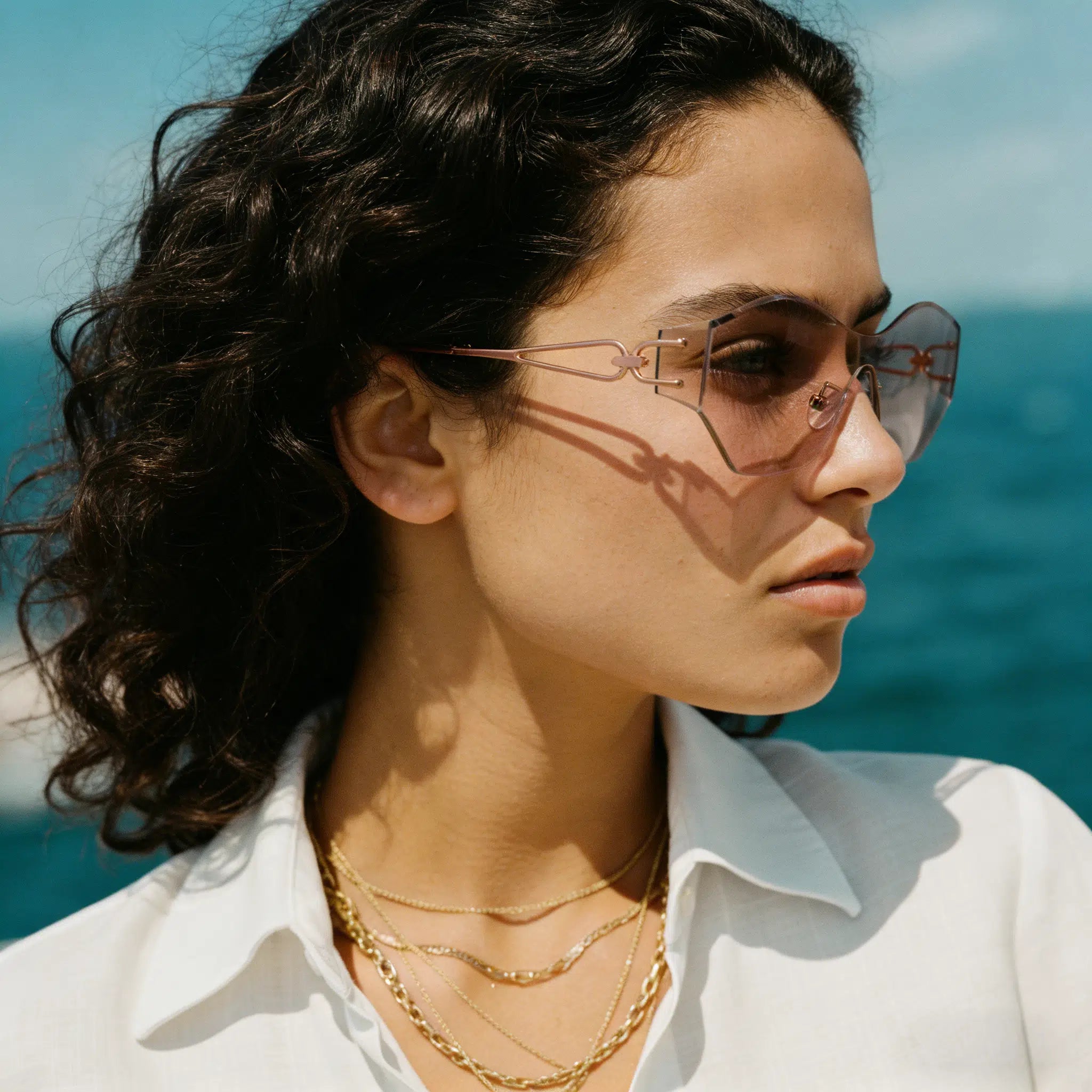 Woman wearing sunglasses with a blurred ocean background
