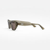 Sunglasses with a beige frame and dark lenses on a white background
