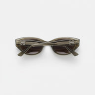 Temple close-up of transparent grey-tea cat-eye sunglasses, BB logo and clear acetate texture